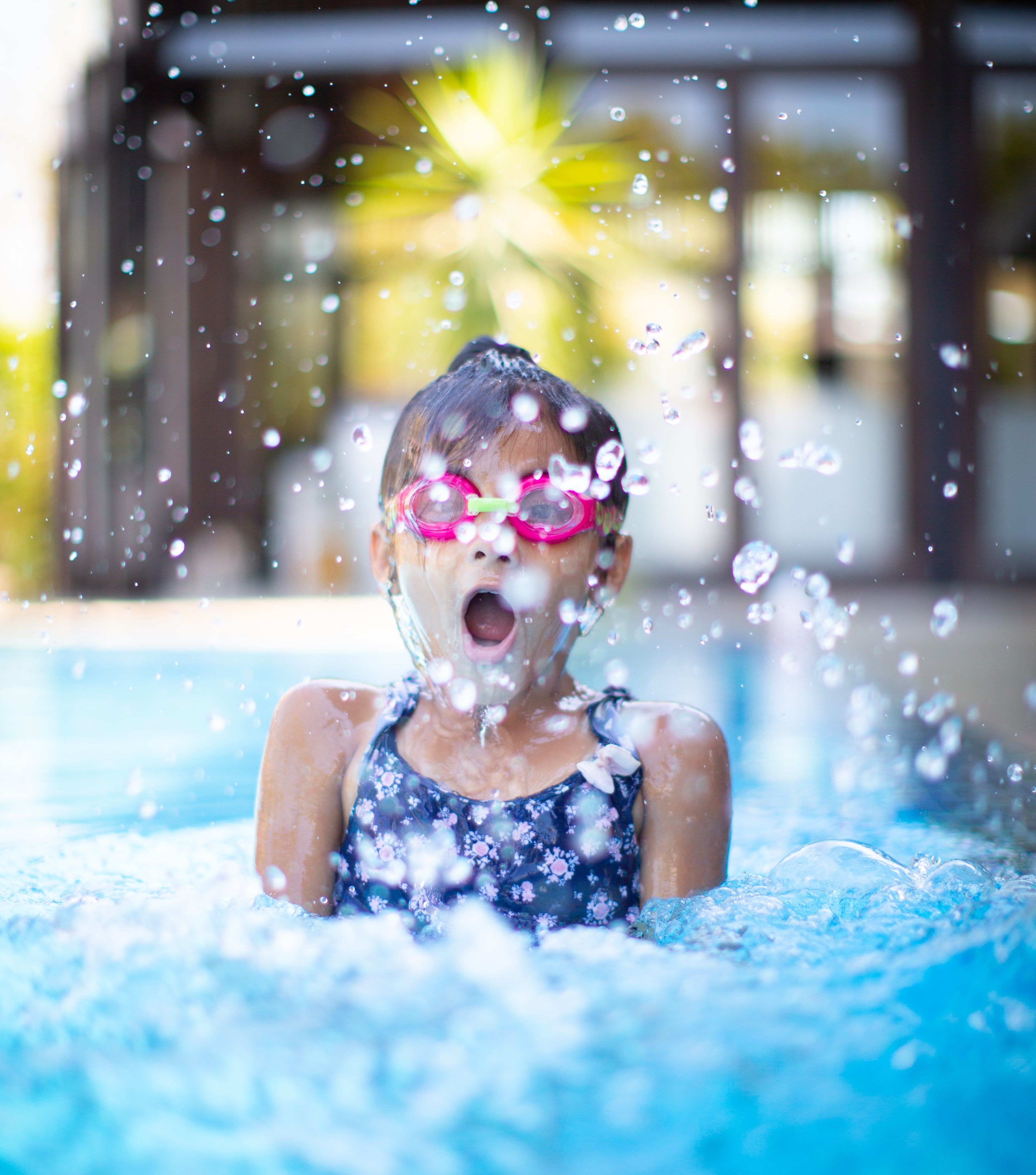 a girl playing in a pool wearing goggles