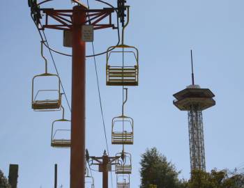 A chair of Ober Gatlinburgs Ski lift and the Gatlinburg space needle with a blue sky